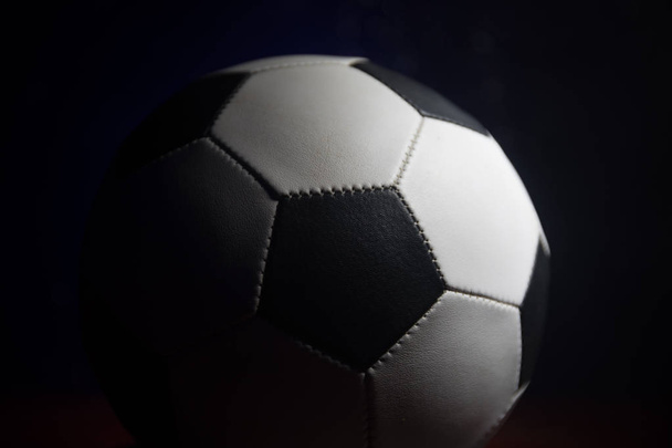 Vue rapprochée du ballon de football sur fond sombre. Jeu de football plan conceptuel. Concentration sélective
 - Photo, image