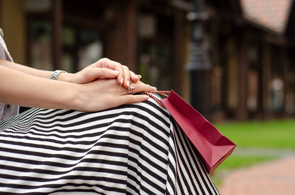 A woman is holding a gift package bag in hand shopping - Fotó, kép