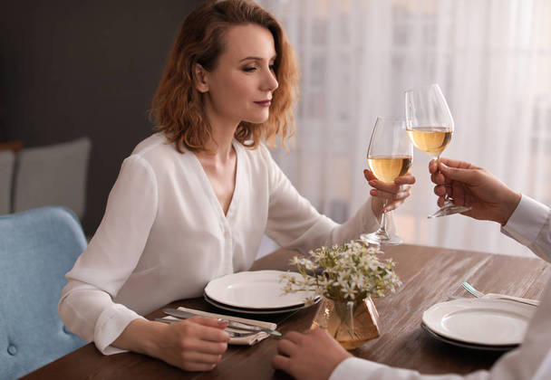 Young couple with glasses of delicious wine in restaurant - Photo, image