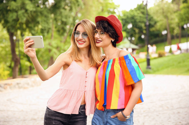 Young women in stylish clothes taking selfie outdoors - Foto, afbeelding