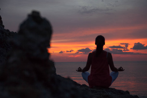 Mulher meditando em uma pose de ioga na praia
 - Foto, Imagem
