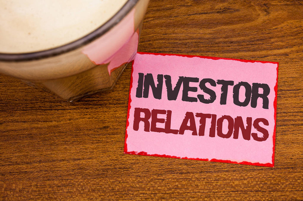 Conceptual hand writing showing Investor Relations. Business photo text Finance Investment Relationship Negotiate Shareholder Wooden desktop red lined pink paper with several texts coffee mug - Photo, Image
