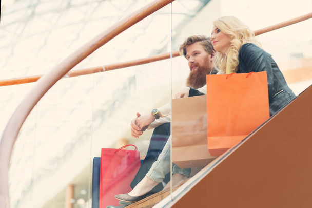 Feliz hermosa pareja joven con bolsas de compras en el centro comercial - Foto, Imagen