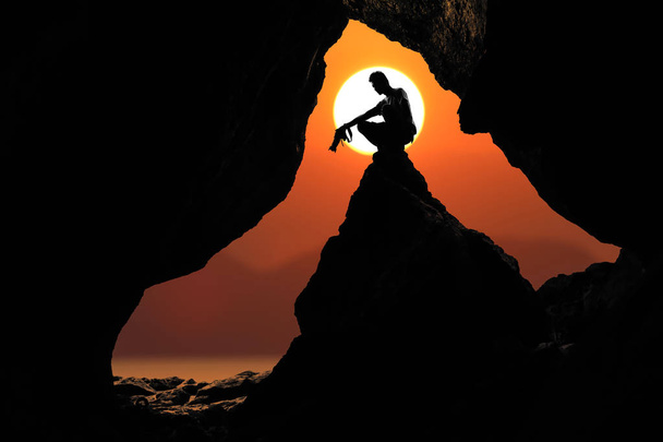 Фотограф перед печерою біля моря з фоном заходу сонця червоного неба
 - Фото, зображення