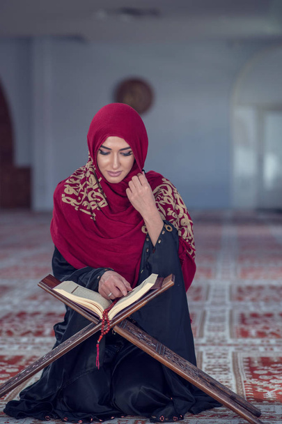 Muslim Woman Reading Koran Or Quran Wearing Traditional Dress At The Mosque. - Foto, Imagen