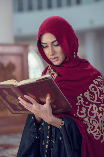 Muslim Woman Reading Koran Or Quran Wearing Traditional Dress At The Mosque - Foto, Imagem