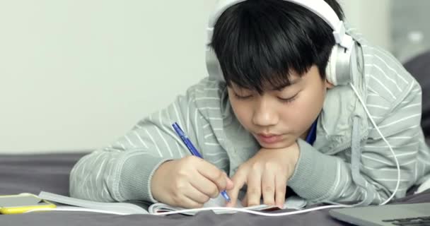 Giovane asiatico adolescente studente ascoltare musica e fare i compiti a casa, Dolly sparare
. - Filmati, video