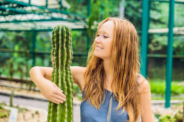 Beauty young woman hugs a cactus as her best friend. Problems of friendship concept. - Foto, imagen