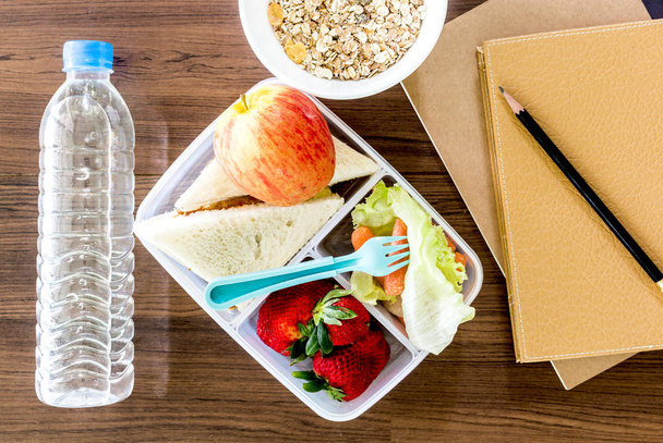Lounas laatikko vihanneksia ja viipale leipää terveen koulun lounas puinen pöytä
 - Valokuva, kuva