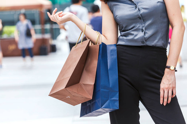 Az utcán sétáló bevásárló táska tartó női - Fotó, kép