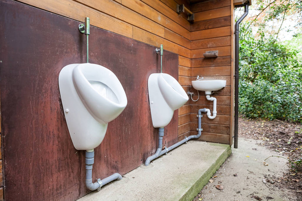 urinarios y fregadero en un edificio viejo solo para hombres
 - Foto, Imagen