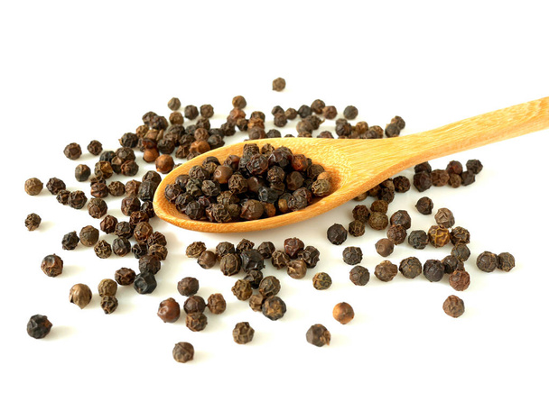 Pile de grains de poivre noir dans une cuillère en bois isolée sur fond blanc
 - Photo, image