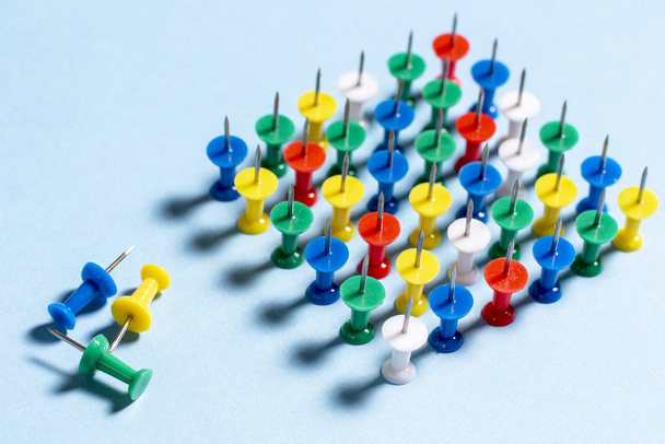 Botões de papelaria multicoloridos em um fundo azul empilhados agulhas para cima
 - Foto, Imagem