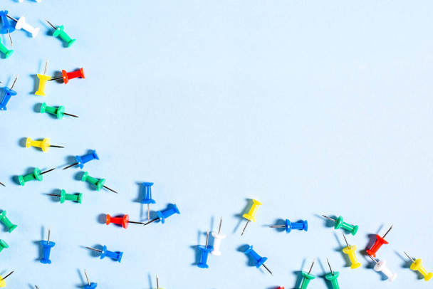 Boutons de papeterie multicolores avec aiguilles sur fond bleu
 - Photo, image
