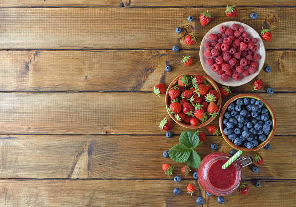 Berry smoothies on a wooden background - Fotoğraf, Görsel