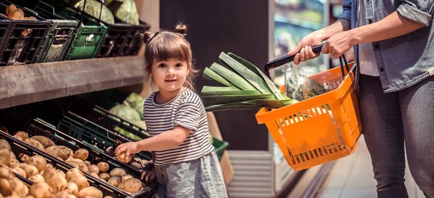 Mãe e filha estão comprando no supermercado, o conceito de relações familiares e alimentação saudável
 - Foto, Imagem