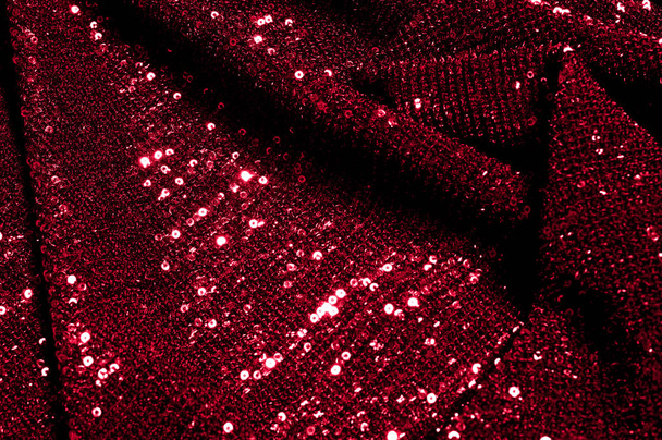 Texture, background, pattern, red fabric with paillettes. Look at these neon red sequins. Round neon pink sparkles glitter overlapping iridescent glitter on a clean purple grid. - Photo, Image