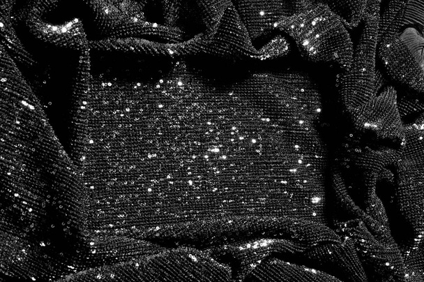 Μαύρο ύφασμα με παγιέτες κάνει ένα εκθαμβωτικό ντεμπούτο αυτό μαύρο μωρό Sequined η επίστρωση της δύναμης της συνεχούς ματιών παραμένει μια πυκνή διάταξη κυκλική glitters για ολόκληρο επίστρωμα - Φωτογραφία, εικόνα