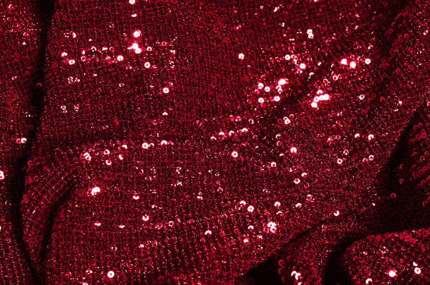 Texture, background, pattern, red fabric with paillettes. Look at these neon red sequins. Round neon pink sparkles glitter overlapping iridescent glitter on a clean purple grid. - Photo, Image