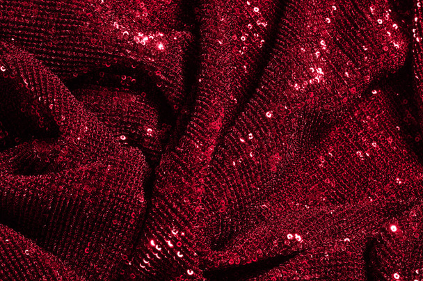 Текстура, фон, візерунок, червона тканина з паєтками. Подивіться на ці неонові червоні блискітки. Круглий неоновий рожевий блиск блищить, що перекриває нерозчинний блиск на чистій фіолетовій сітці
. - Фото, зображення