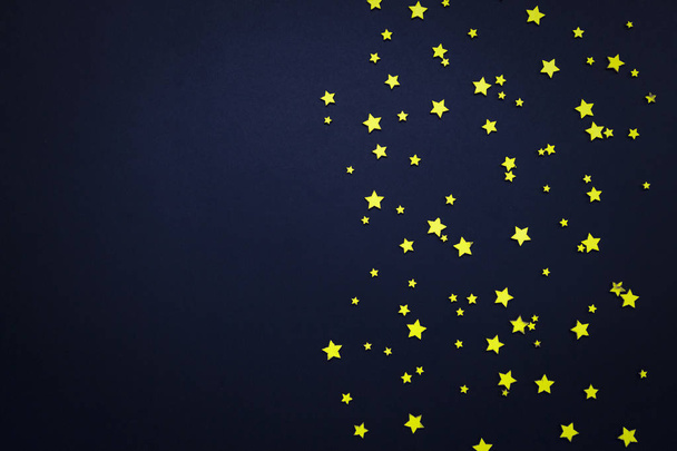 Estrelas decorativas sobre um fundo azul escuro. Conceito do céu noturno. Pode ser usado como papel de parede ou fundo. Deitado plano, vista superior
. - Foto, Imagem