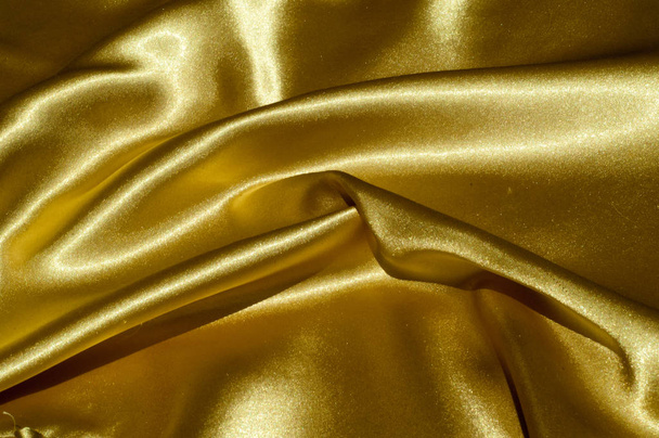 Texture, fabric, background. Abstract background of luxurious fabric or liquid waves or wavy grunge crease silk satin texture of velvet material or luxurious Christmas or elegant background. gold - Valokuva, kuva