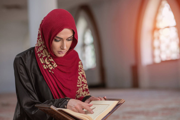 Muslim Woman Reading Koran Or Quran Wearing Traditional Dress At The Mosque - Zdjęcie, obraz