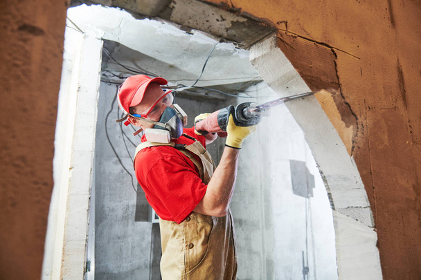 Worker sawing doorway with sabre saw. Home renovation - Zdjęcie, obraz