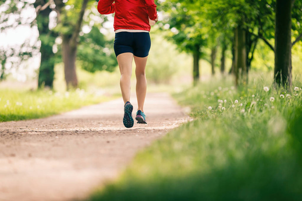 Running woman, enjoying summer day in park. Endurance training, jogging or power walking female athlete, physical activity concept outdoors. - Valokuva, kuva