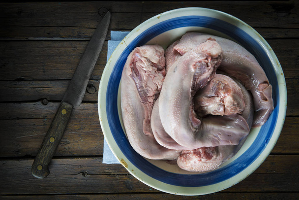 Γλώσσες χοιρινό κρέας ωμό και φρέσκο σε ένα ρετρό μπολ - Φωτογραφία, εικόνα