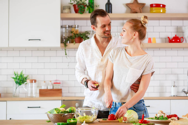 Photo of young couple in love preparing breakfast in kitchen - Photo, Image