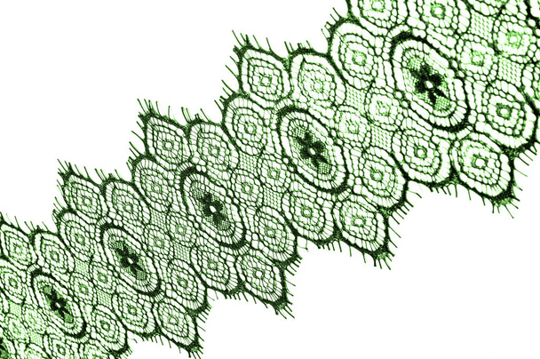textura, fondo, patrón. tela de encaje. Verde. Impresionantes flores bordadas florecen en el borde a lo largo de ambos bordes, mientras que esporádicamente crece a través del medio del tul puro
. - Foto, Imagen