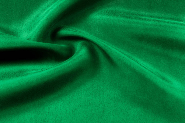 背景テクスチャ、パターン。厚い厚いシルク生地は緑色です。このサテンの生地はデザインでスムーズな流れを作成するために理想的なそれは液体のドレープと絶妙な輝き. - 写真・画像