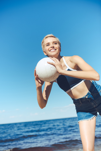 портрет улыбающейся женщины с волейболом на пляже в летний день
 - Фото, изображение