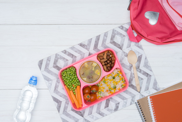 top view of tray with kids lunch for school and copybooks on white tabletop - Foto, Imagen