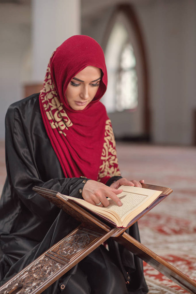 Muslim Woman Reading Koran Or Quran Wearing Traditional Dress At The Mosque - Foto, imagen