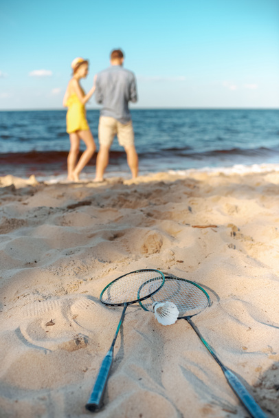 Selektywny fokus badminton sprzęt i para na plaży - Zdjęcie, obraz