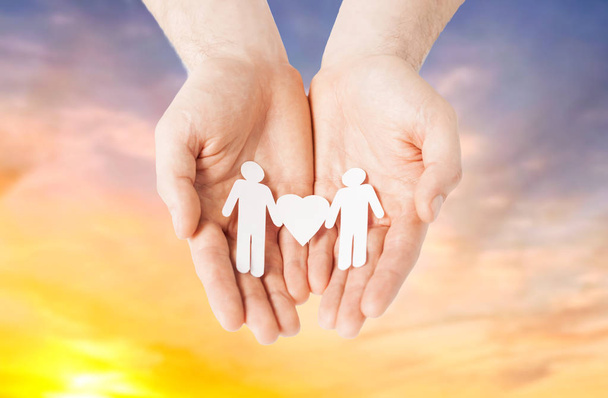 male hands holding paper gay couple pictogram - Foto, immagini