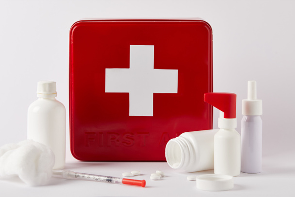 аптечка з порожніми медичними пляшками, шприцом та ватним тампоном на білому
 - Фото, зображення