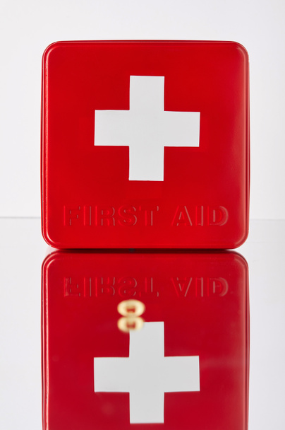 boîte de trousse de premiers soins rouge avec capsule oméga sur la surface réfléchissante
 - Photo, image