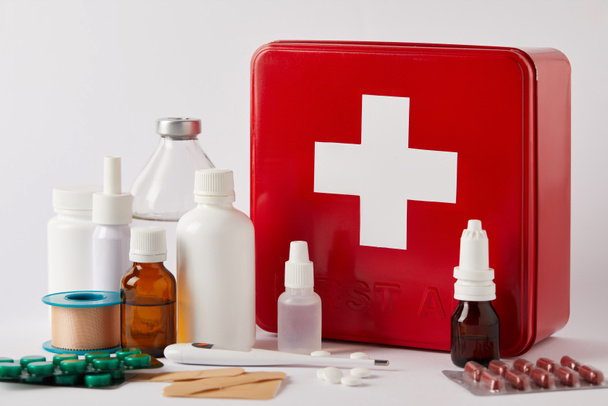 close-up shot of first aid kit box with different medical bottles and supplies on white - Photo, Image