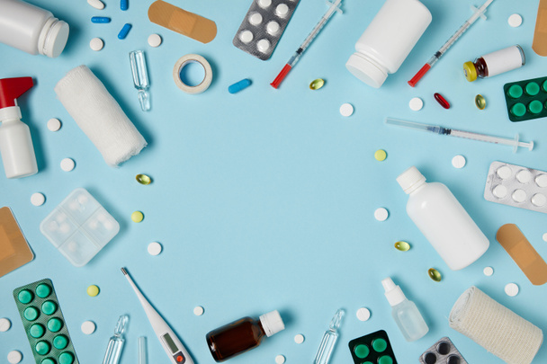 vista superior do quadro feito de diferentes medicamentos na superfície azul
 - Foto, Imagem