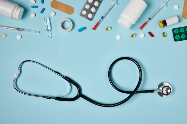 Widok z góry stetoskop i różne leki na powierzchni niebieski - Zdjęcie, obraz