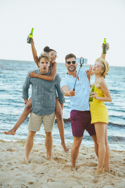 interracial young friends with beer taking selfie by sea - Photo, Image