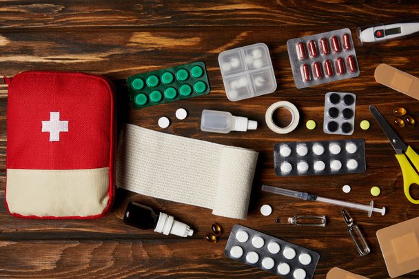 木製卓上型で様々 な薬と応急キットの袋の上から見る - 写真・画像