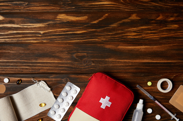 top view of first aid kit with different medicines on wooden tabletop - Photo, Image