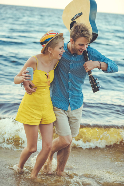 happy couple with soda drink and acoustic guitar walking on beach - Fotografie, Obrázek