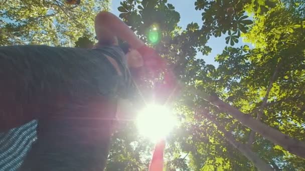 Mujer atractiva joven envolviendo las manos con vendajes rojos preparándose para el entrenamiento en el parque de verano
 - Metraje, vídeo