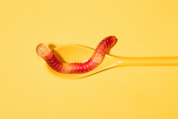 top view of gummy worm on spoon and on yellow - Photo, Image