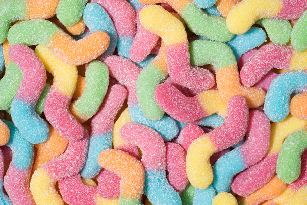 volledige frame shot van kleurrijke gummy wormen bedekt met suiker - Foto, afbeelding